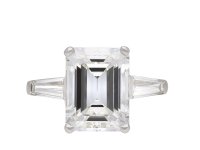 Emerald cut diamond flanked solitaire ring, circa 1960. Hatton Garden