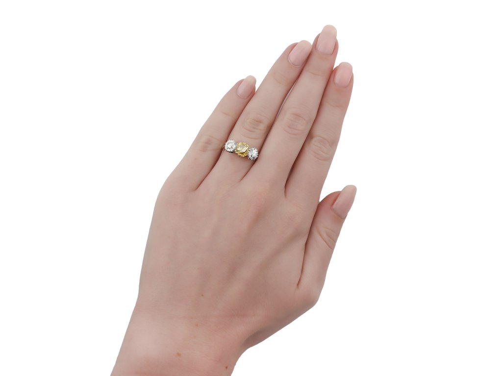 Fancy brownish orangy yellow diamond three stone ring, English, circa 1905.