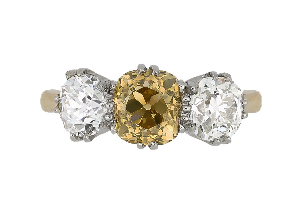 Fancy brownish orangy yellow diamond three stone ring, English, circa 1905.