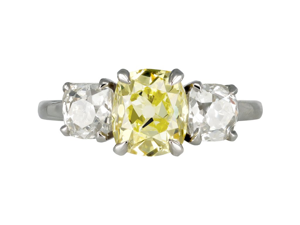 Fancy intense yellow diamond three stone ring.