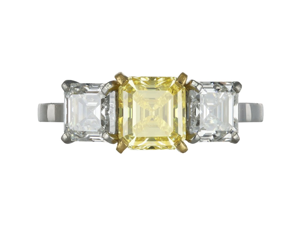 Fancy vivid yellow diamond three stone ring.