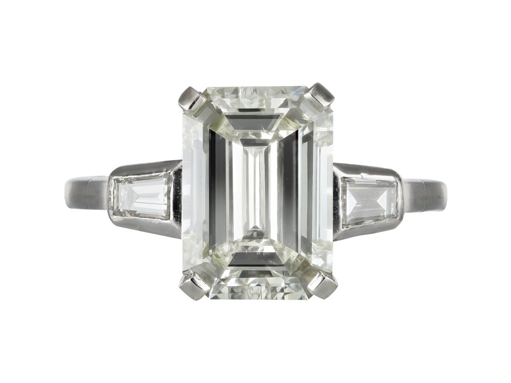 Emerald cut diamond flanked solitaire ring, circa 1950.