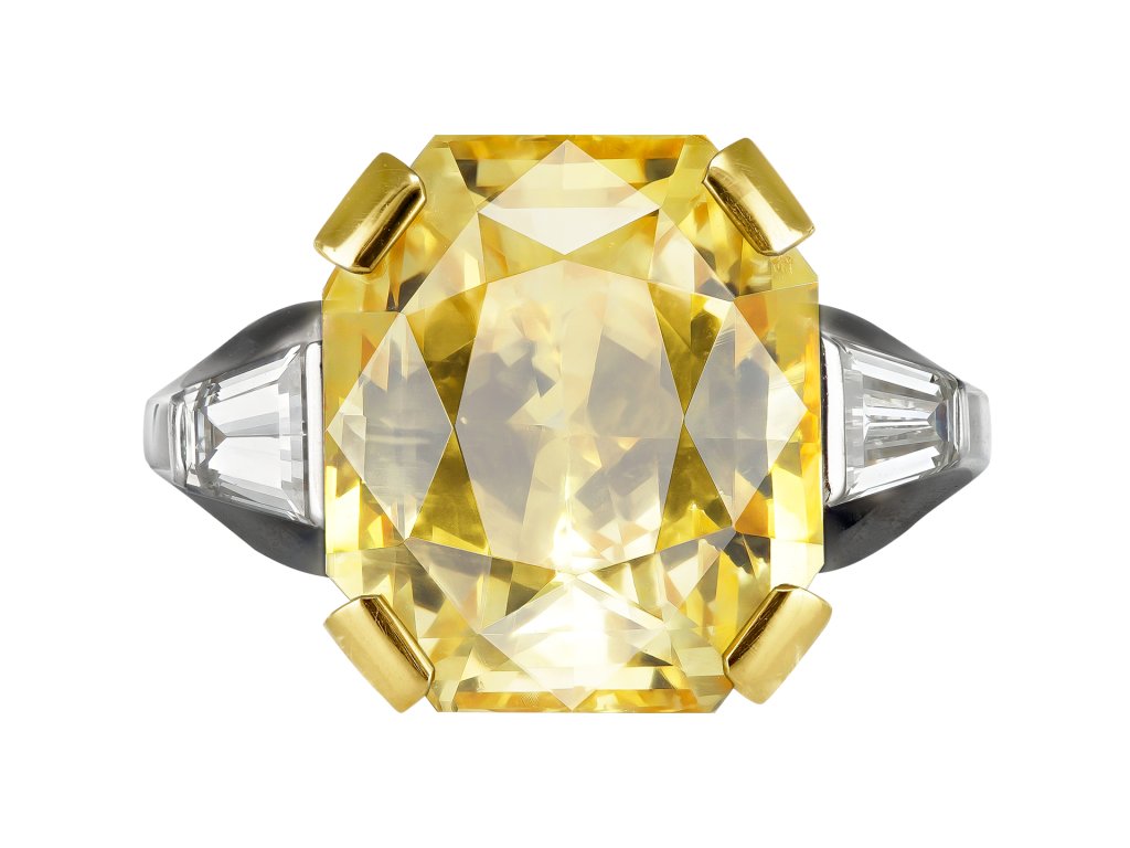 Yellow Ceylon sapphire and diamond flanked solitaire ring, English, 1986. 