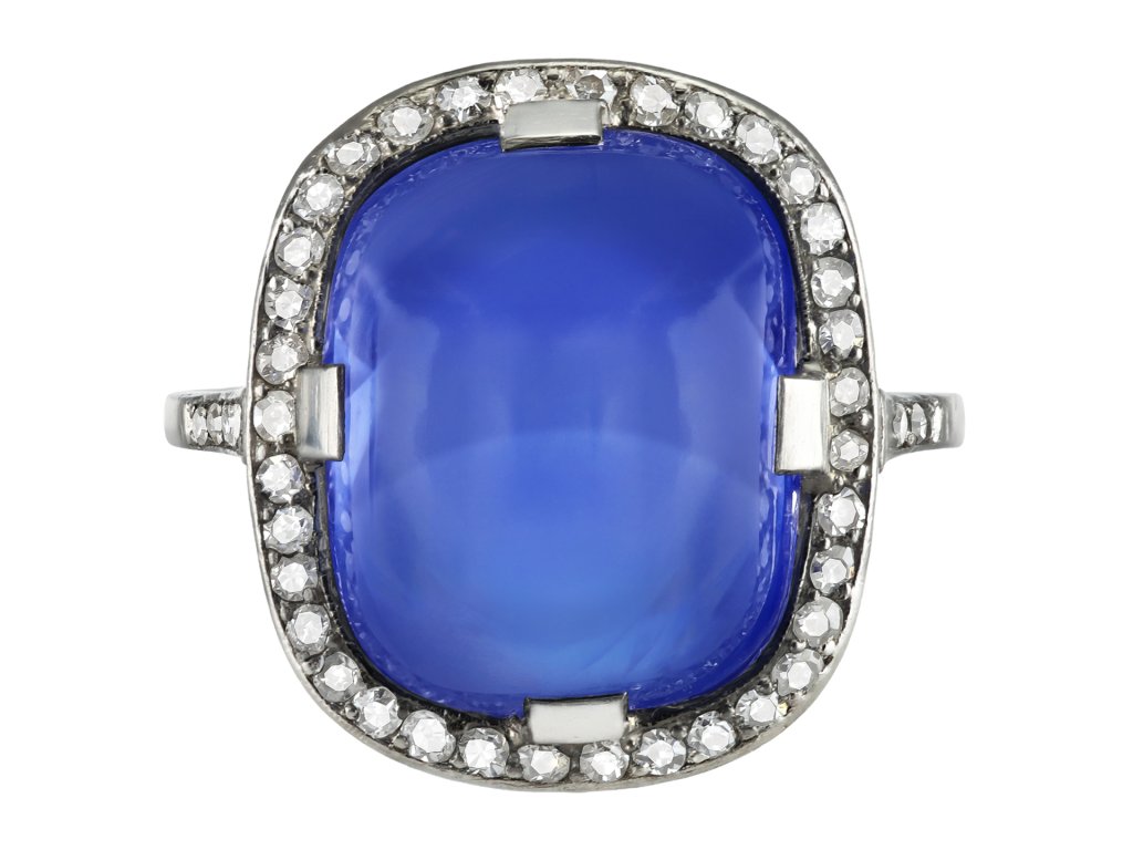 Ceylon cabochon sapphire and diamond cluster ring, early 20th Century. 