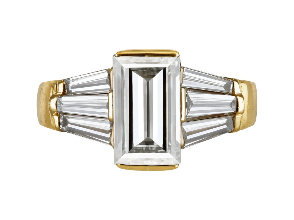 Rectangular step cut diamond flanked solitaire ring, late 20th Century. 