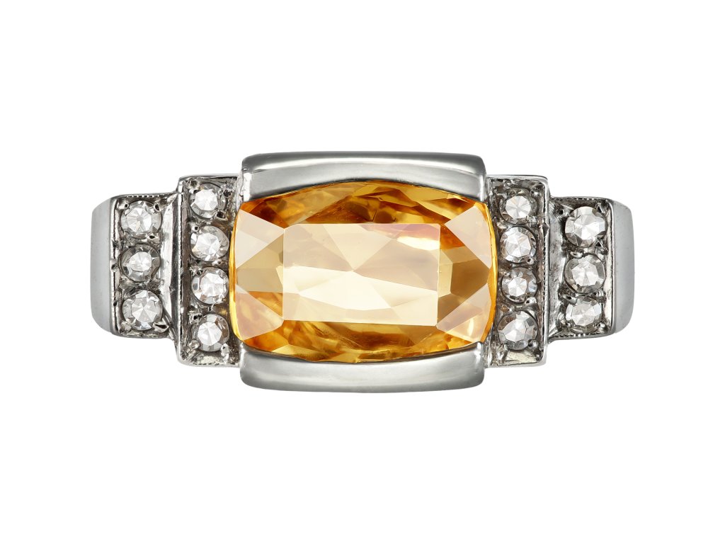 Orange Ceylon sapphire and diamond flanked solitaire ring, mid 20th century.