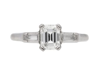 Emerald-cut diamond flanked solitaire ring, American, circa 1950.