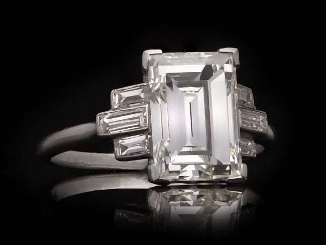 Art Deco flanked solitaire step cut diamond ring, circa 1925. Hatton Garden