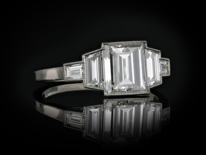 Art Deco step cut diamond flanked solitaire ring, circa 1925. 