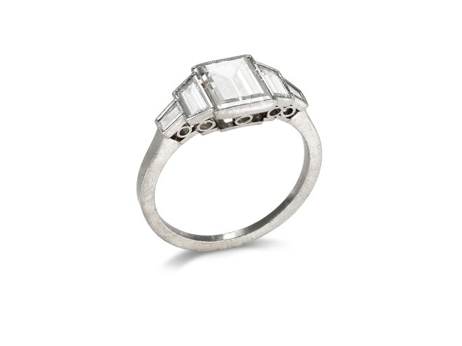 Art Deco step cut diamond flanked solitaire ring, circa 1925. 