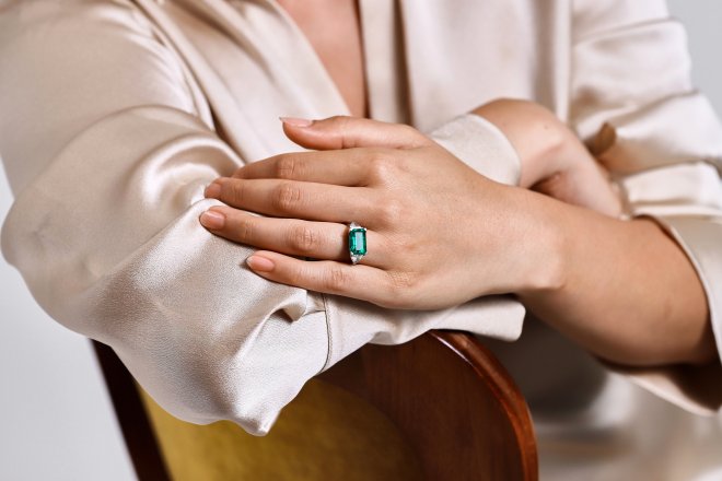 Colombian emerald and diamond flanked solitaire ring.