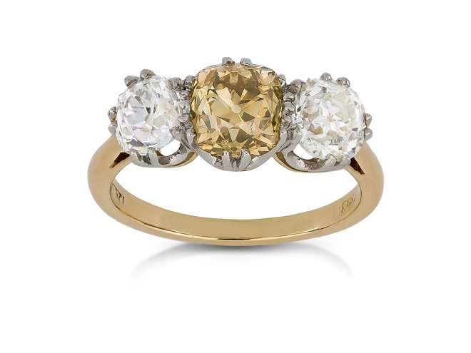 Fancy brownish orangy yellow diamond three stone ring, English, circa 1905.