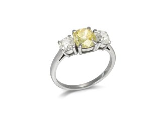 Fancy intense yellow diamond three stone ring.