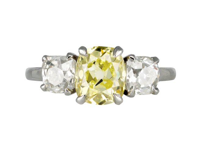 Fancy intense yellow diamond three stone ring.