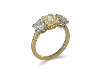 Fancy intense yellow diamond three stone ring, English, circa 1910.
