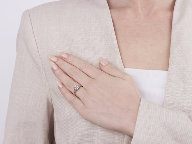A diamond ring featuring an emerald cut centre stone