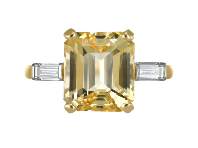 Yellow Ceylon sapphire and diamond flanked solitaire ring, circa 1950. 