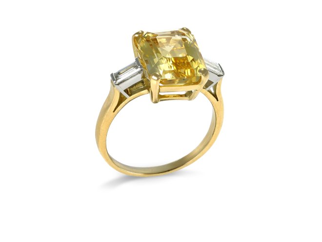 Yellow Ceylon sapphire and diamond flanked solitaire ring, circa 1950. 