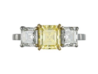 Fancy vivid yellow diamond three stone ring.