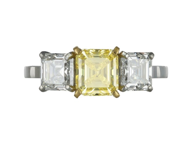 Fancy vivid yellow diamond three stone ring.