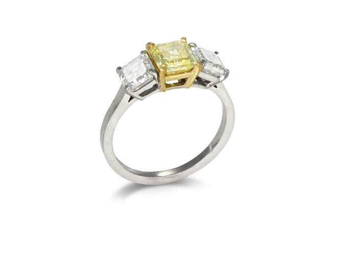 Fancy vivid yellow diamond three stone ring.