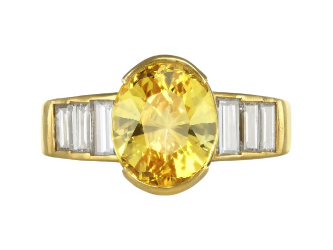 Yellow Ceylon sapphire and diamond flanked solitaire ring, circa 1970. 