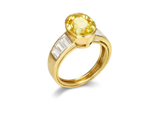 Yellow Ceylon sapphire and diamond flanked solitaire ring, circa 1970. 