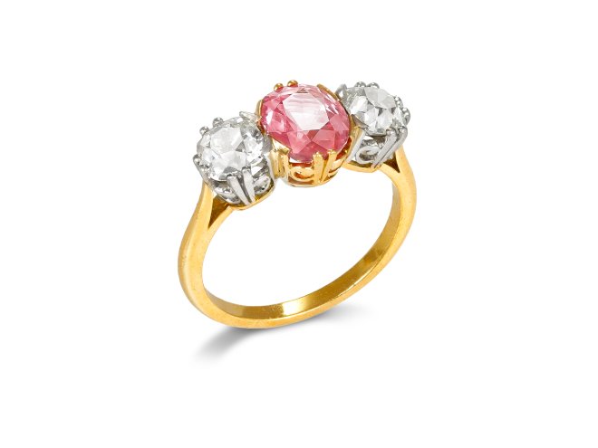 Padparadscha Ceylon sapphire and diamond three stone ring, circa 1910.