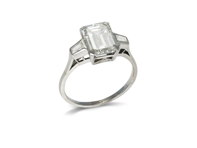 Emerald cut diamond flanked solitaire ring, circa 1950.