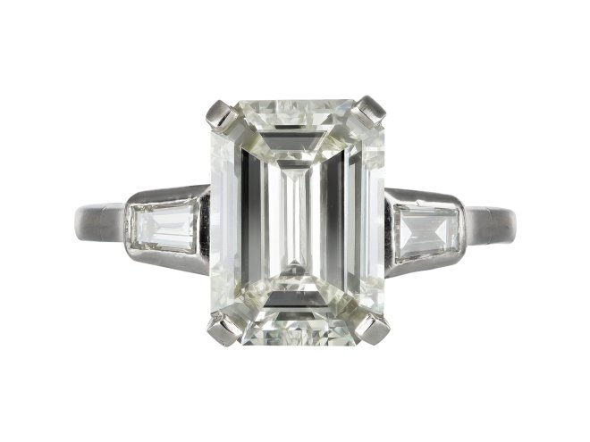 Emerald cut diamond flanked solitaire ring, circa 1950.