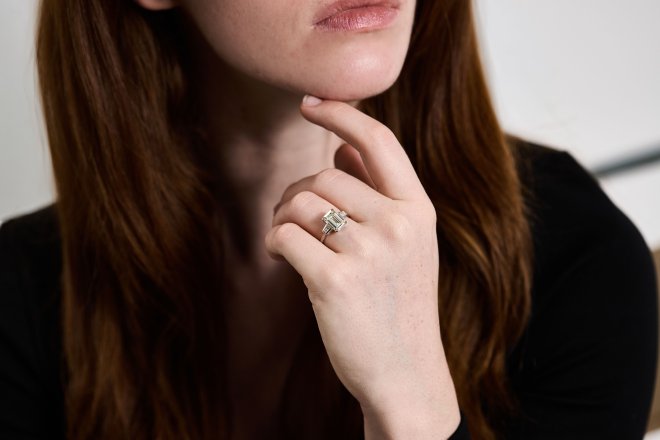 Emerald cut diamond flanked solitaire ring, circa 1950.