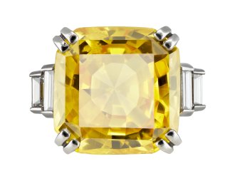 Yellow Ceylon sapphire and diamond flanked solitaire ring, mid 20th Century. 