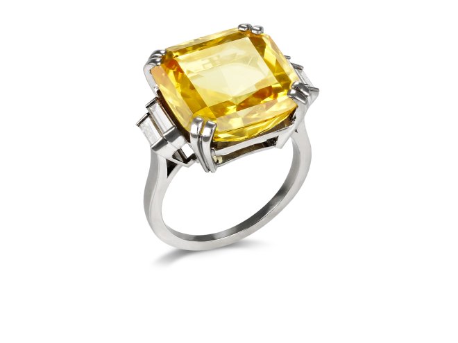 Yellow Ceylon sapphire and diamond flanked solitaire ring, mid 20th Century. 