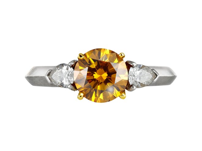 Tiffany & Co Fancy deep orange yellow diamond flanked solitaire, American.